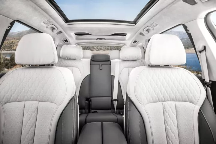 Amplia cabina del BMW X7 con techo panorámico y asientos en cuero blanco.