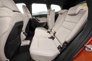 Vista lateral de los asientos traseros del BMW X1, mostrando espacio y tapicería.