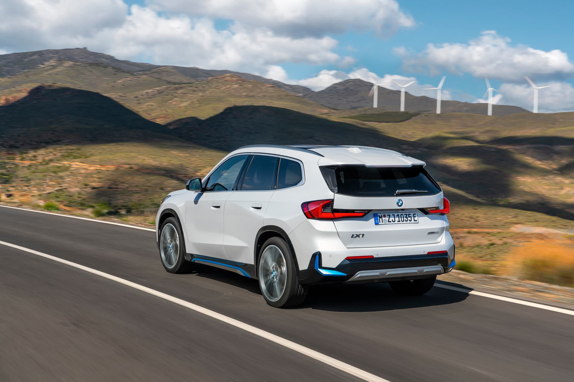 Vista dinámica del BMW X1 en carretera, destacando su diseño trasero y lateral.