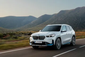 BMW X1 mostrando su diseño frontal y lateral en carretera de montaña