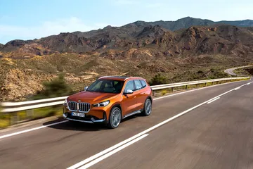 Vista dinámica del BMW X1 lateral en carretera de montaña.
