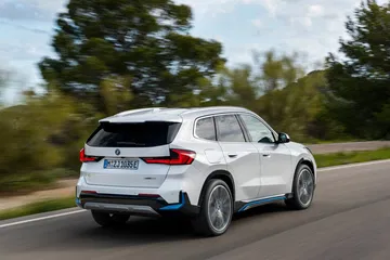 BMW X1 mostrando su perfil dinámico y su diseño trasero en movimiento.