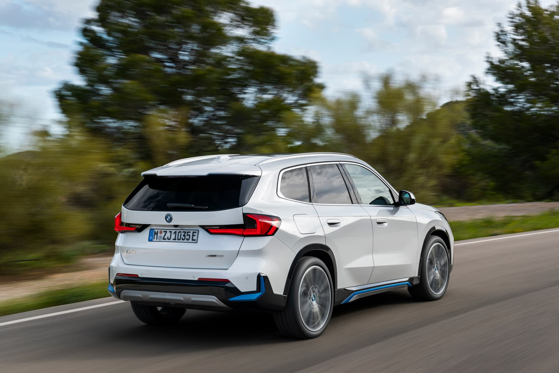 BMW X1 mostrando su perfil dinámico y su diseño trasero en movimiento.