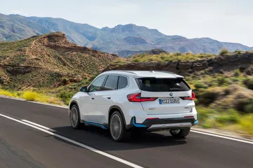 Vista dinámica del BMW X1 en carretera, destacando su diseño lateral.