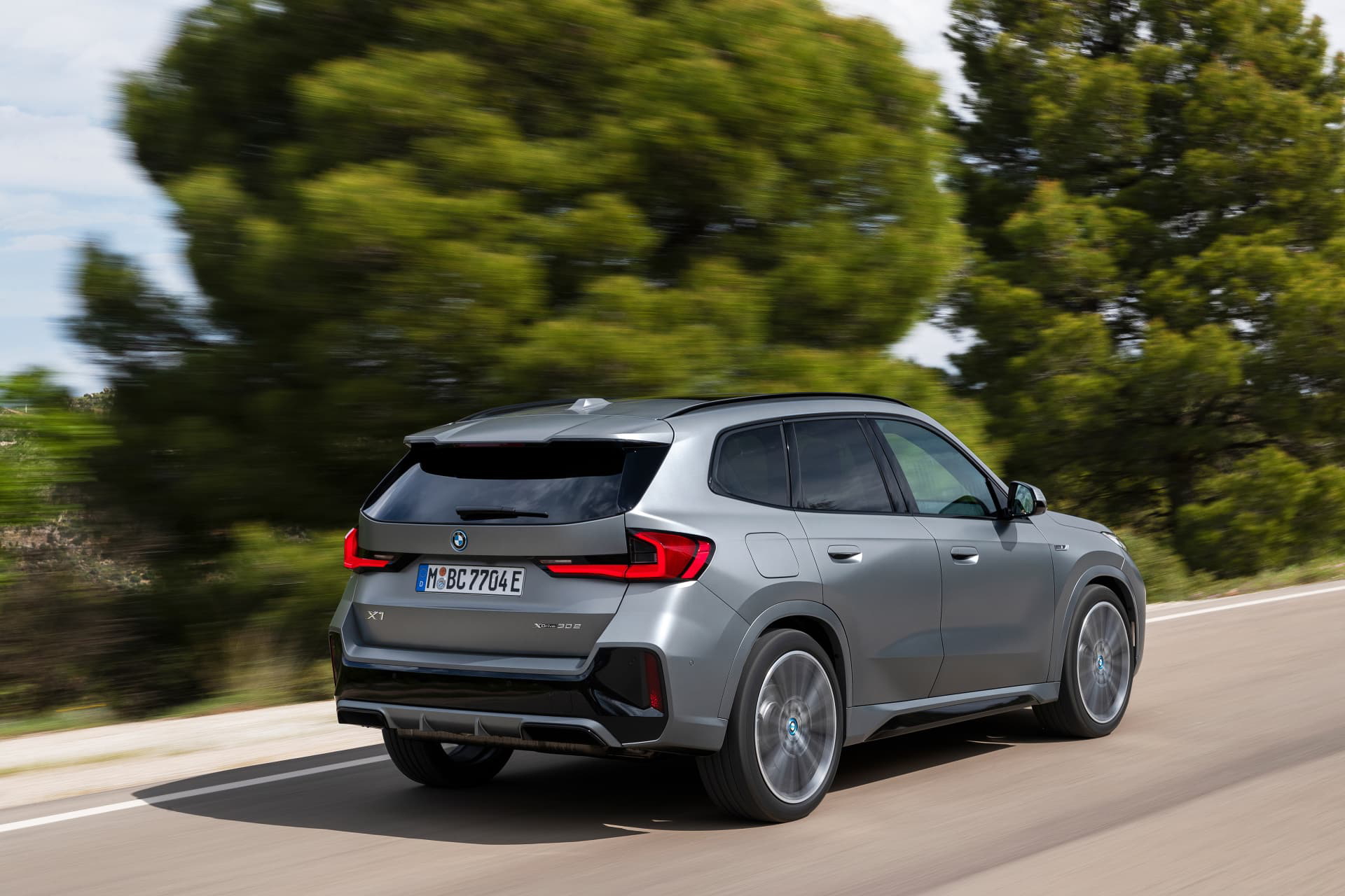 Vista dinámica del BMW X1 en movimiento, destacando su diseño trasero y lateral.