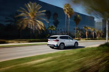 BMW X1 mostrando su diseño lateral y trasero en movimiento.