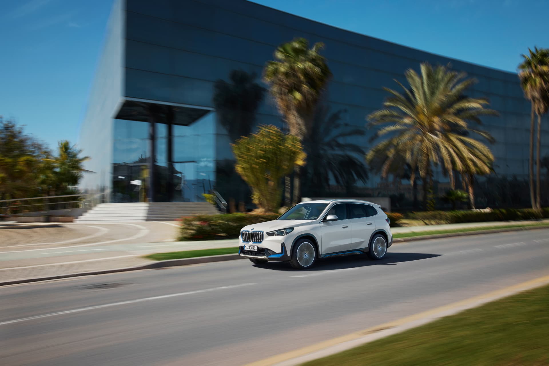 Vista lateral del BMW X1 en movimiento por una vía urbana.