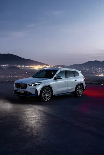Vista lateral del BMW X1 al atardecer destacando su diseño elegante.