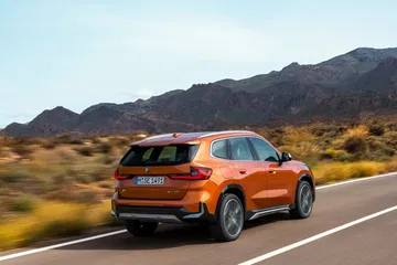 Vista dinámica BMW X1 mostrando su diseño trasero y perfil lateral.
