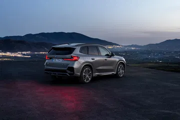 BMW X1 exhibiendo su diseño trasero y lateral al atardecer