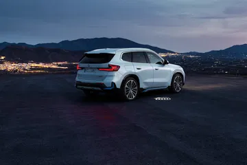Vista nocturna trasera-lateral del BMW X1, resaltando su diseño y luces.