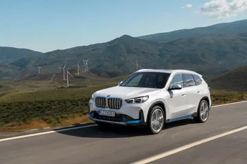 BMW X1 en movimiento, mostrando una impecable vista lateral y delantera.