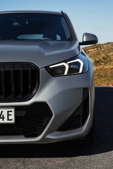 Vista focalizada en el diseño frontal y lateral del BMW X1, destacando su parrilla y faros.