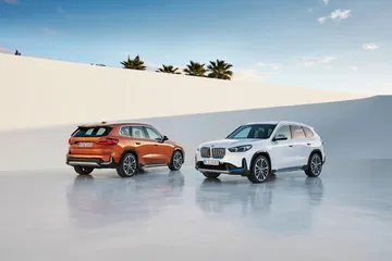 Vista delantera y lateral de dos modelos BMW X1 en diferentes colores.