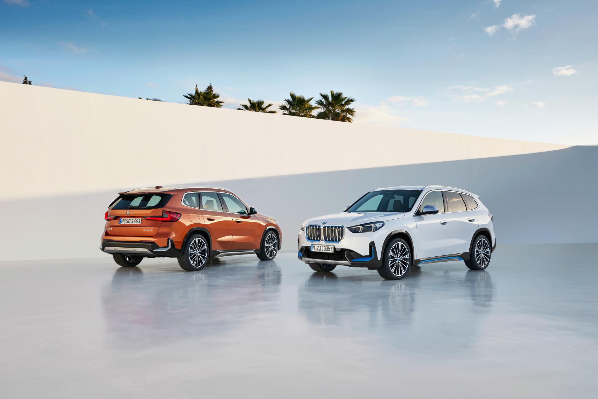 Vista delantera y lateral de dos modelos BMW X1 en diferentes colores.
