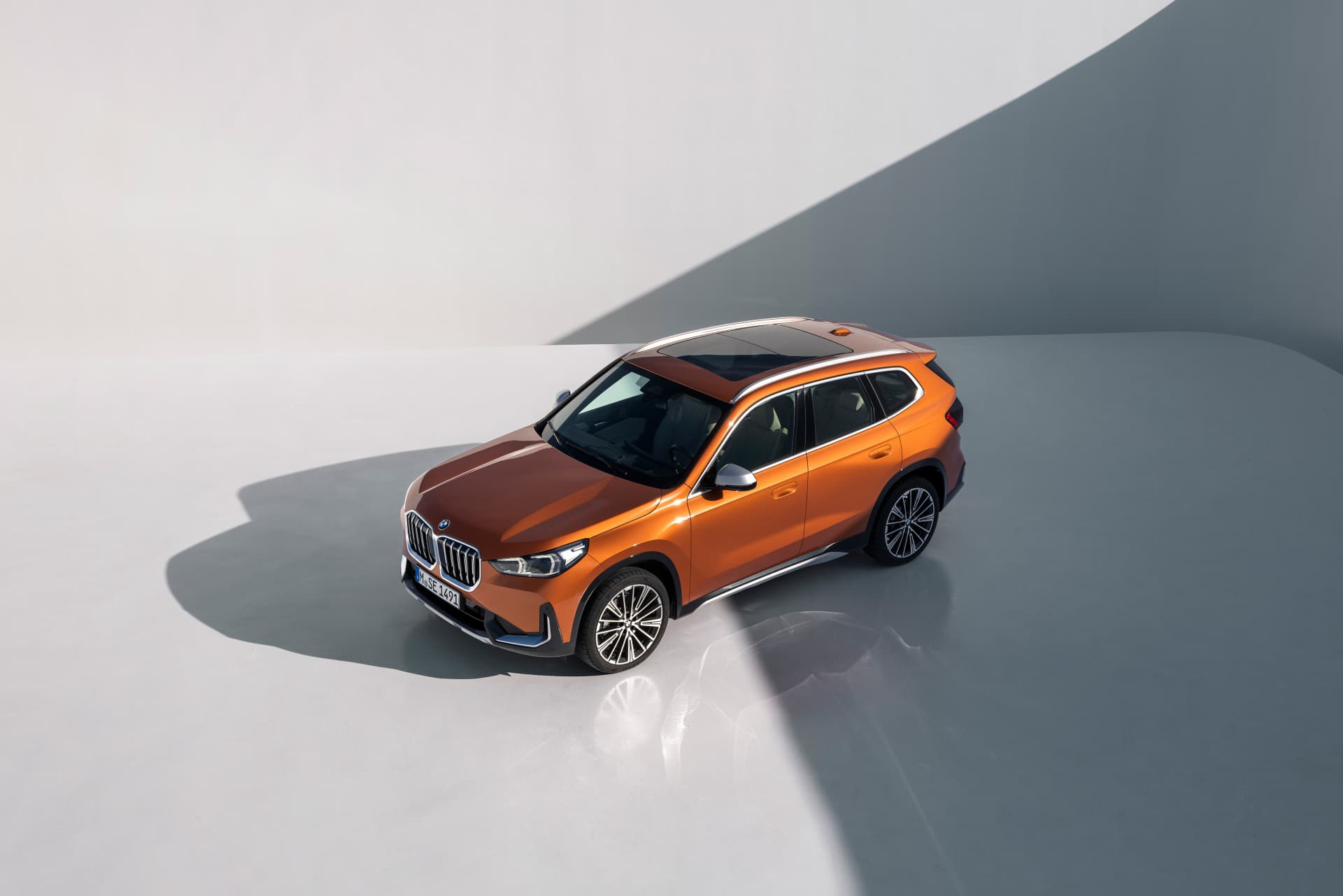 BMW X1 captado desde una perspectiva aérea, destacando su diseño lateral y techo.