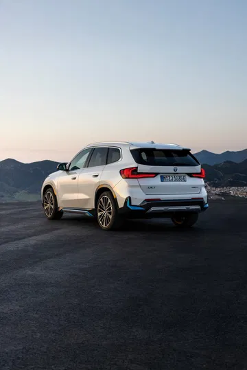 Vista trasera y lateral de un BMW X1 con luz ambiental al amanecer