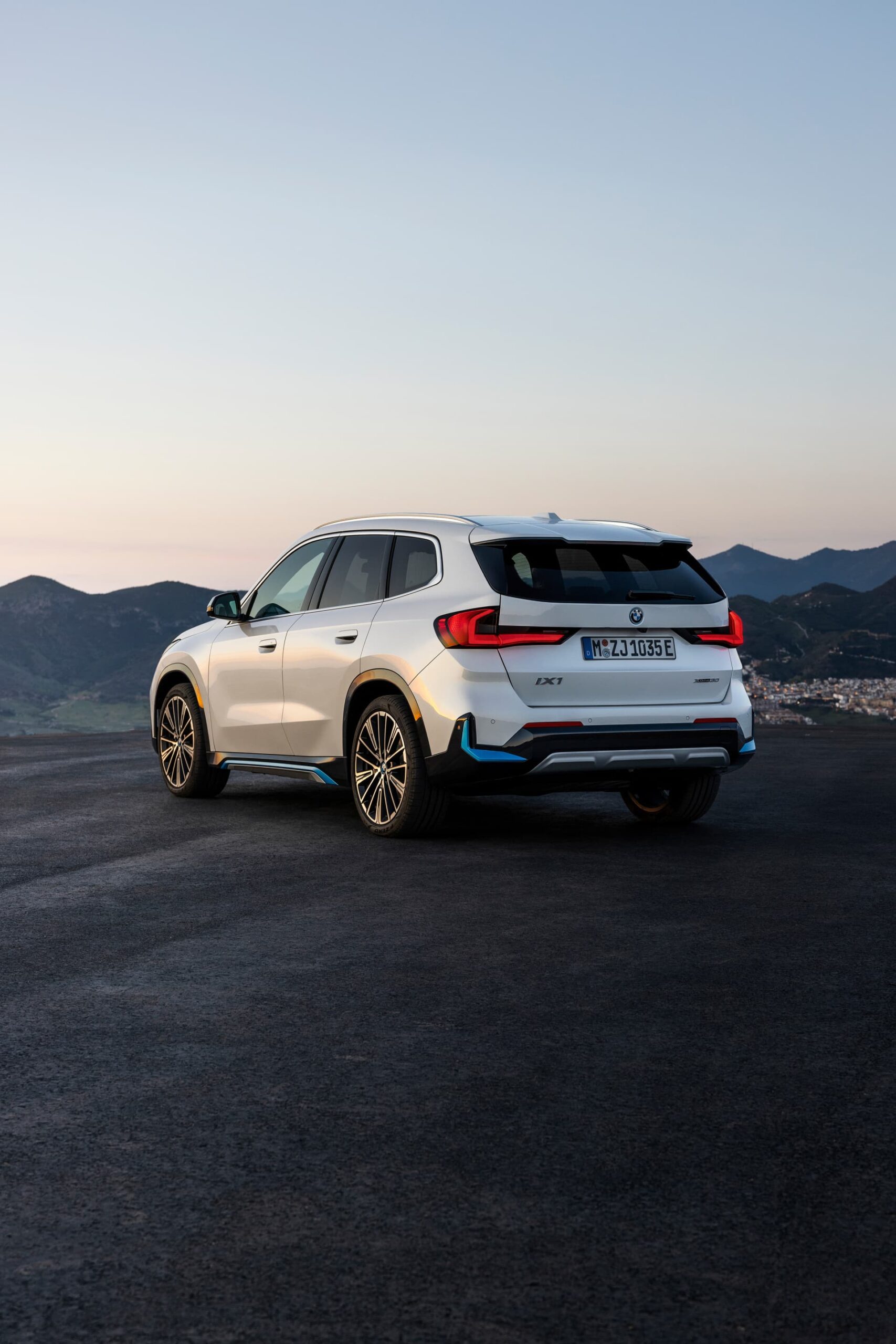 Vista trasera y lateral de un BMW X1 con luz ambiental al amanecer