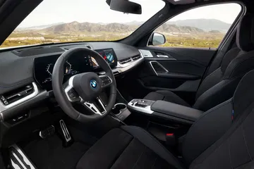 Vista del habitáculo enfocando asientos y volante deportivo.