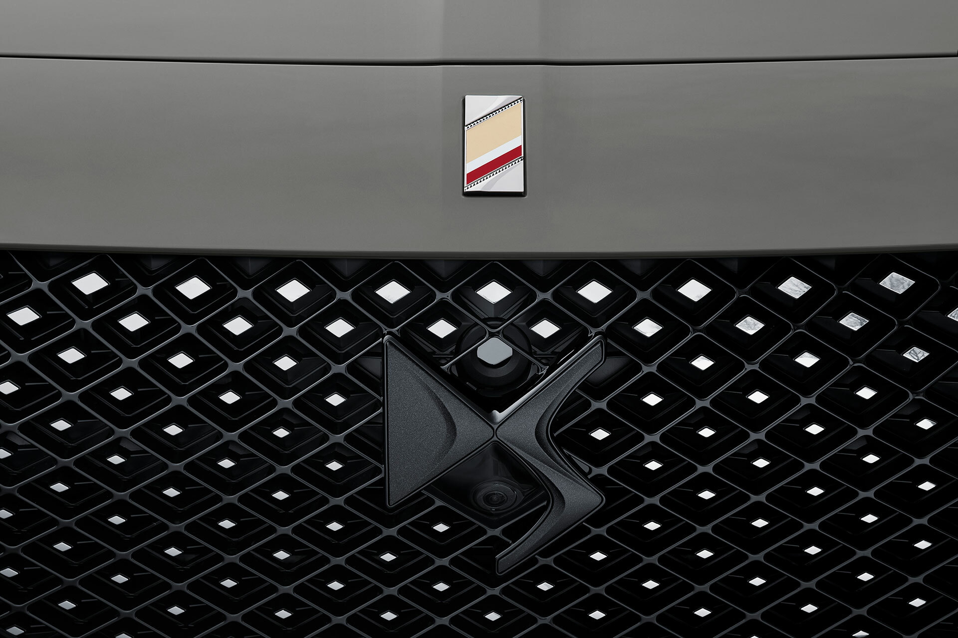 Parrilla frontal del DS 7 con detalle del emblema y diseño en punta de diamante.