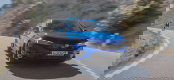 Vista dinámica del Honda Civic en carretera, mostrando su perfil delantero y lateral.