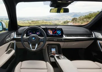 Vista delantera del habitáculo con volante y panel de instrumentos digital.