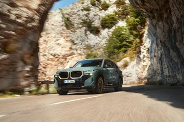 BMW XM en plena acción destacando su diseño lateral robusto y deportivo.