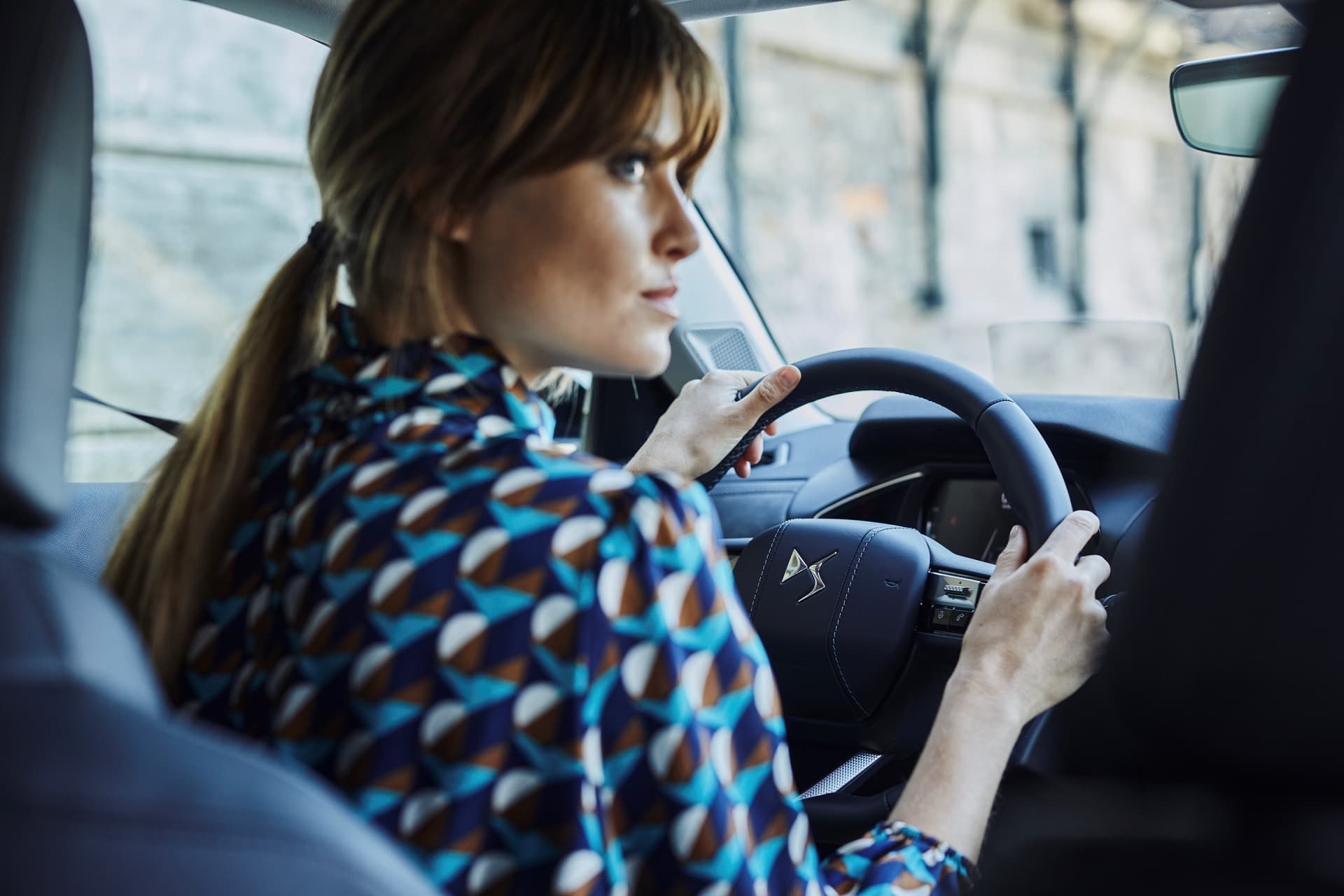 Mujer al volante del DS 3 destacando el diseño interior y la ergonomía.