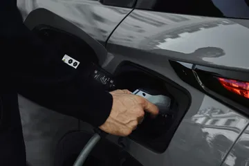 Mano conectando el cargador al DS 3, destaca la tecnología eléctrica.