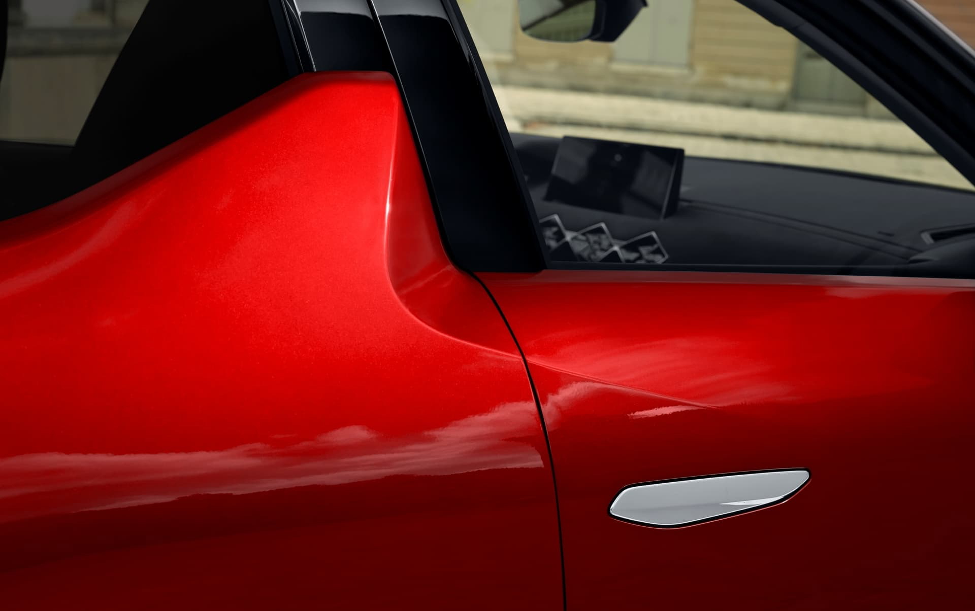 Vista cercana de la manija de la puerta trasera del DS 3, acabado en rojo.