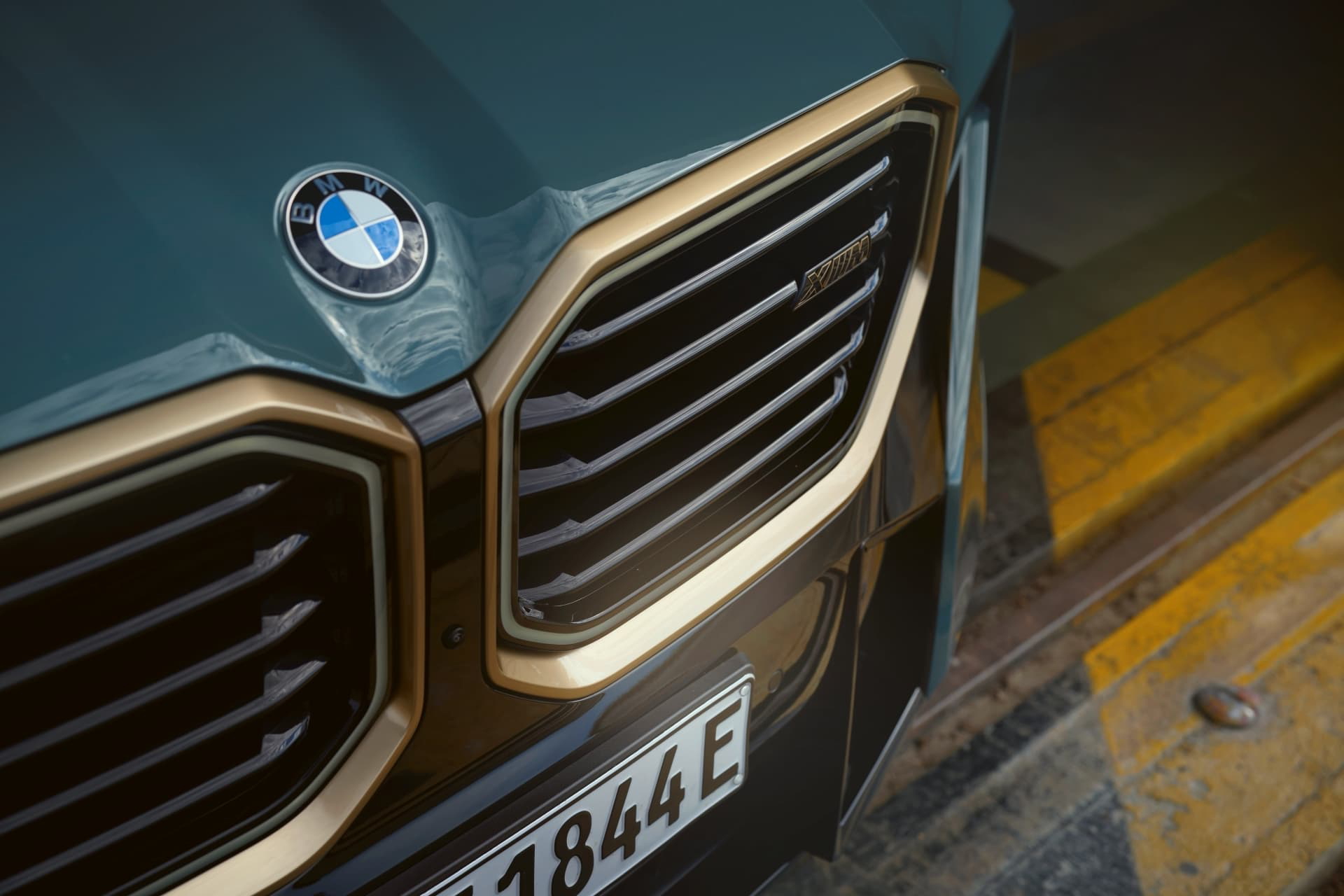 Primer plano de la parrilla distintiva del BMW XM con acabados en bronce.