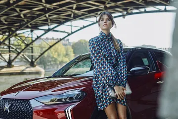 Vista lateral del DS 3 con modelo, mostrando el diseño de las puertas y las llantas.