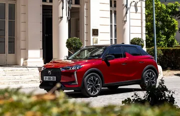 Vista lateral delantera del DS 3 en entorno urbano, destacando su línea dinámica.