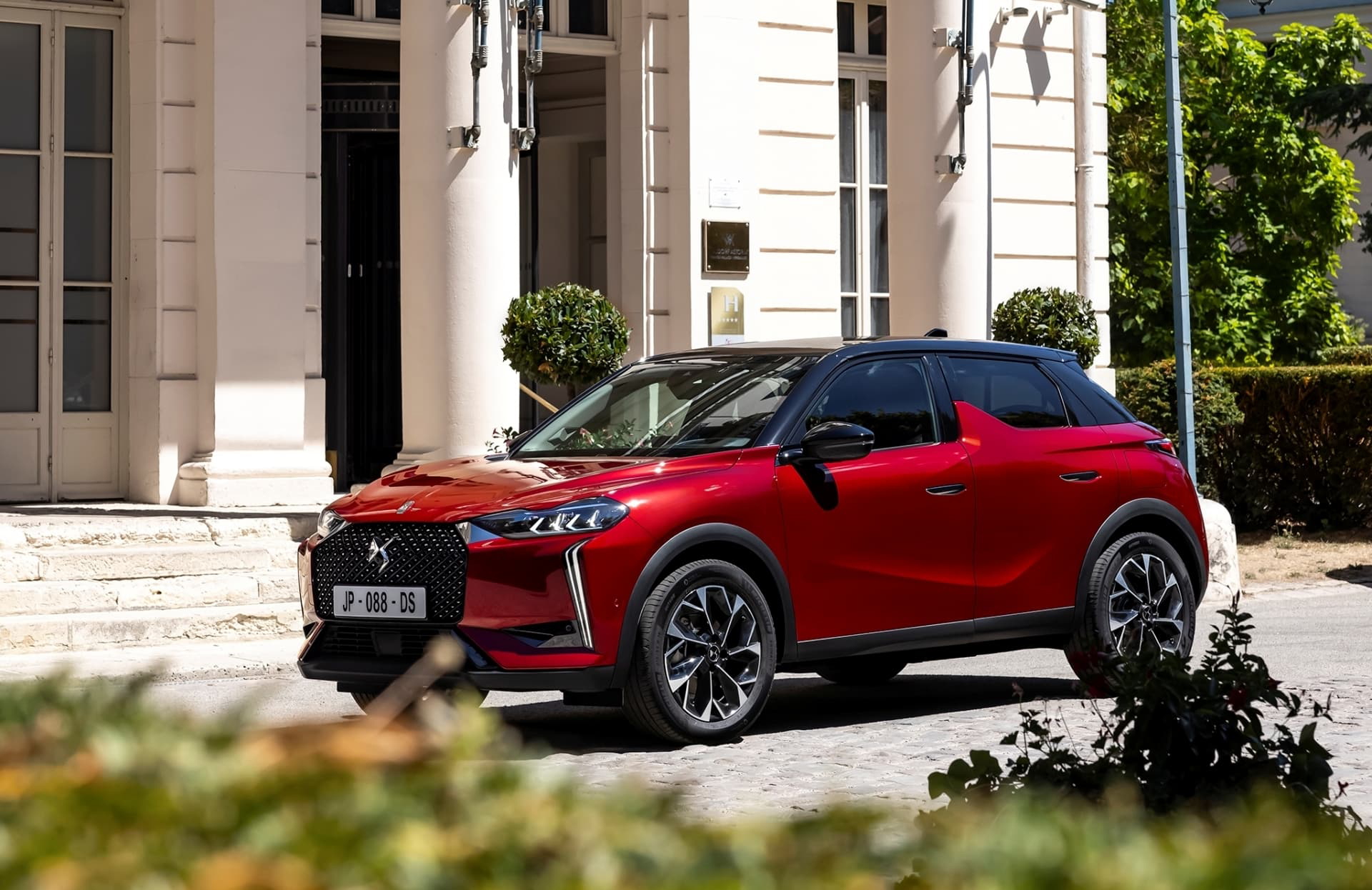 Vista lateral delantera del DS 3 en entorno urbano, destacando su línea dinámica.