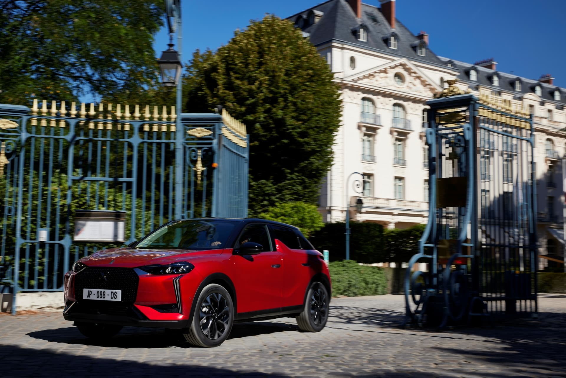 Vista lateral de un DS 3 rojo en un entorno urbano, destacando su diseño vanguardista.