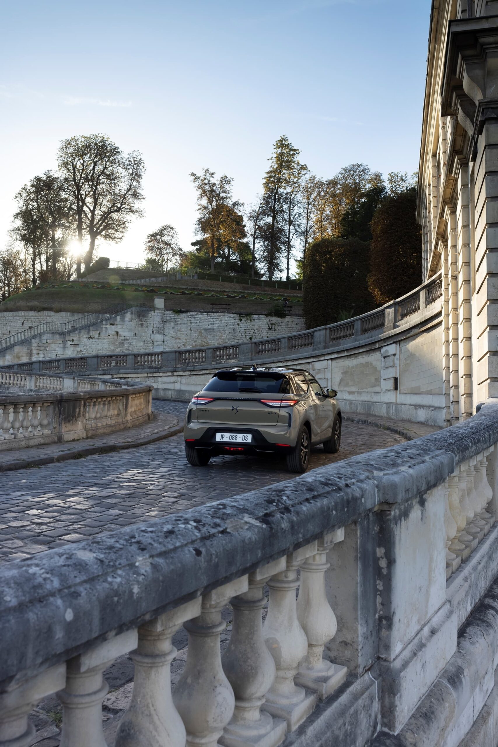 Vista trasera y lateral del DS 3 destacando su diseño y elegancia en un entorno urbano.