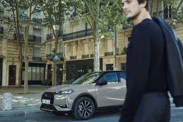 Vista lateral del DS 3 en un entorno urbano, destacando su diseño elegante.