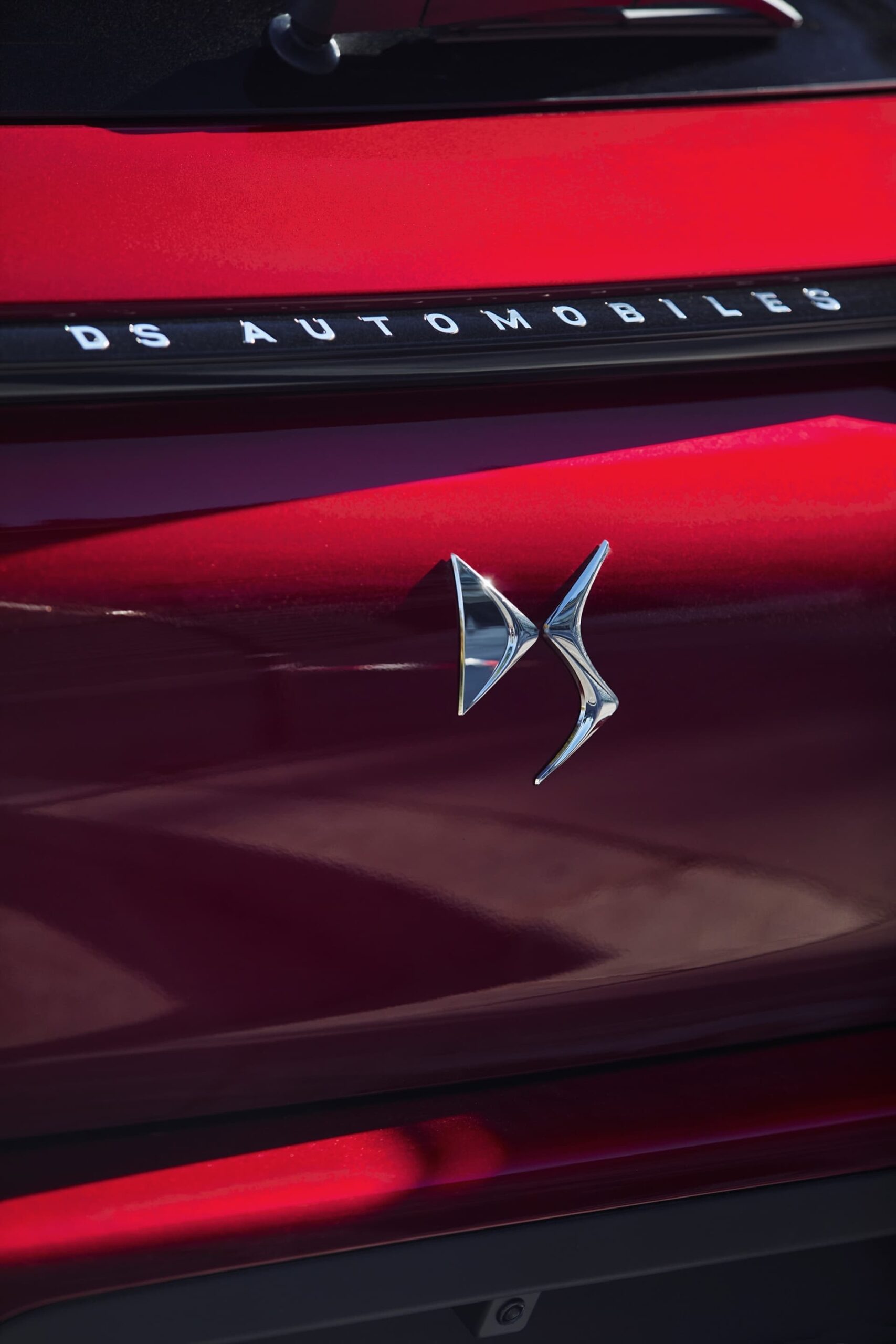 Vista cercana del emblema de DS Automobiles en carrocería roja.
