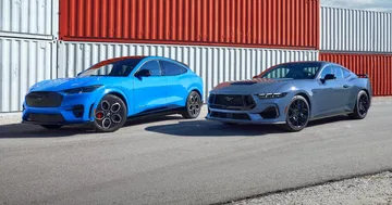 Dos Ford Mustang con una audaz pintura azul y gris vista lateral.