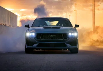 Vista frontal del Ford Mustang desplegando potencia y estilo en humo ardiente.