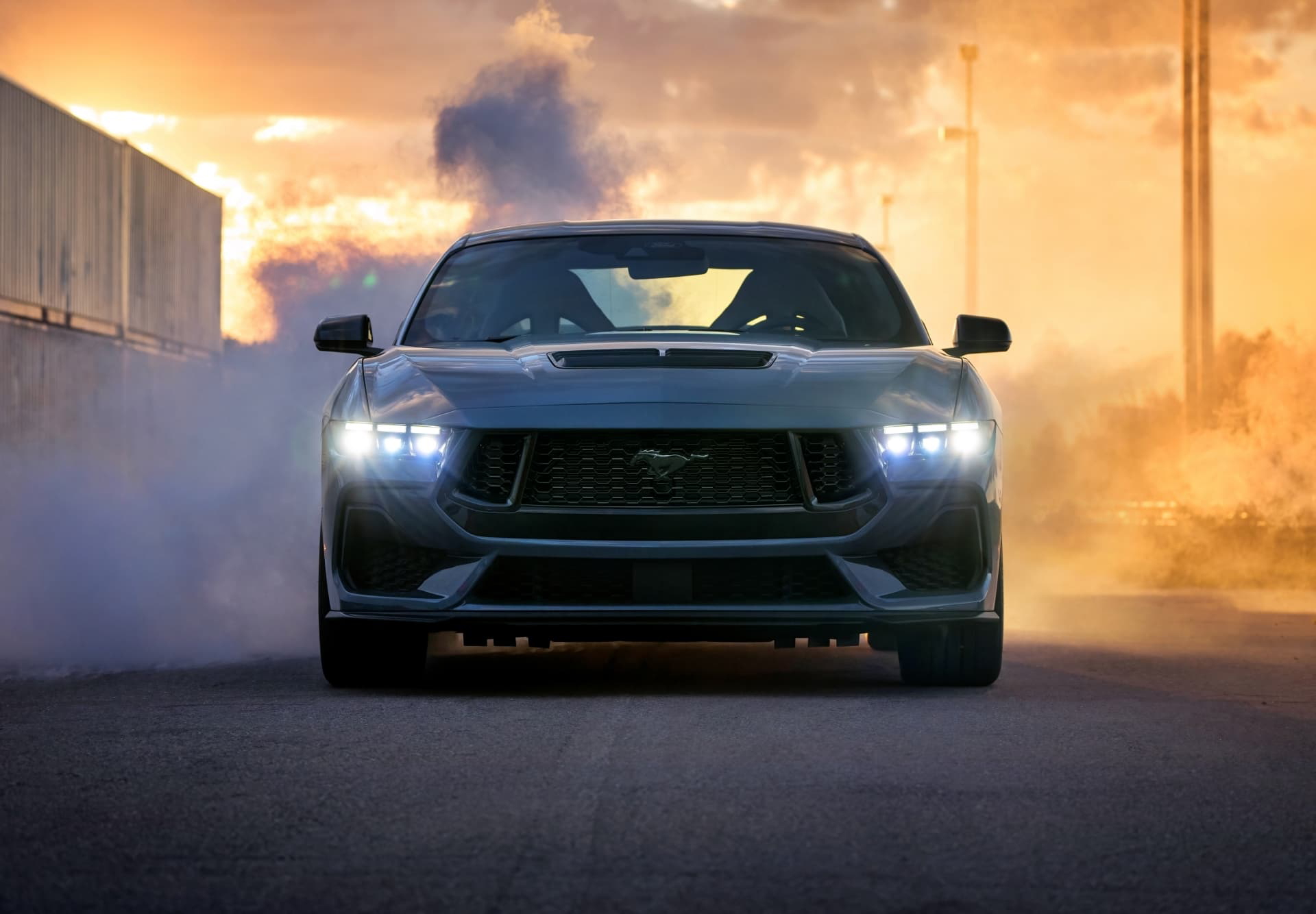 Vista frontal del Ford Mustang desplegando potencia y estilo en humo ardiente.