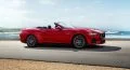 Ford Mustang convertible en color rojo, perfil lateral con playa de fondo.