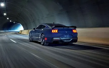 Vista dinámica trasera-lateral de un Ford Mustang en un túnel.
