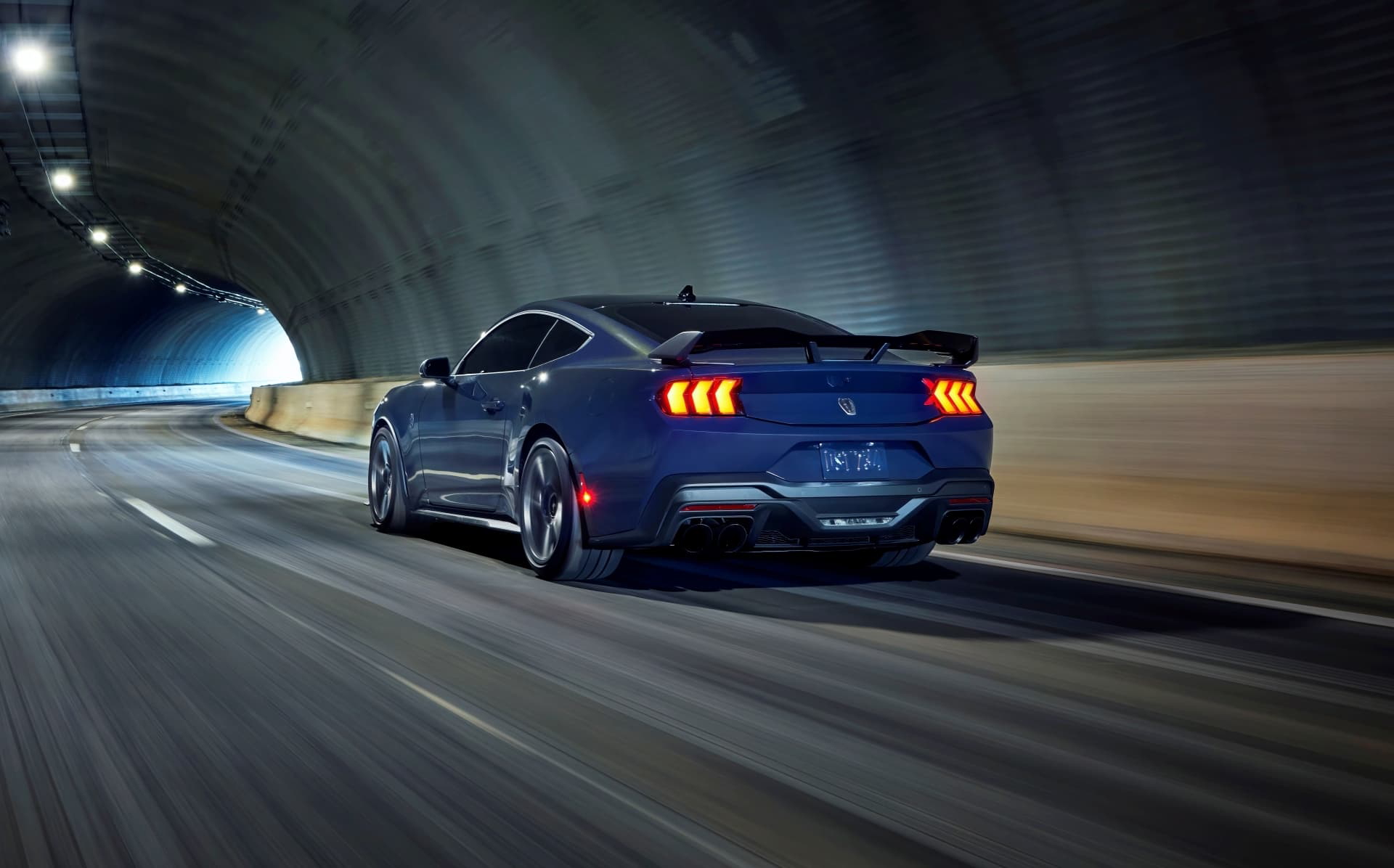 Vista dinámica trasera-lateral de un Ford Mustang en un túnel.