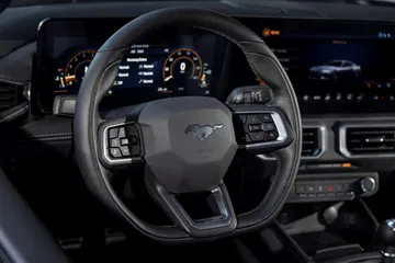 Vista nocturna del volante y panel de instrumentos del Mustang, destacando su iluminación y ergonomía.