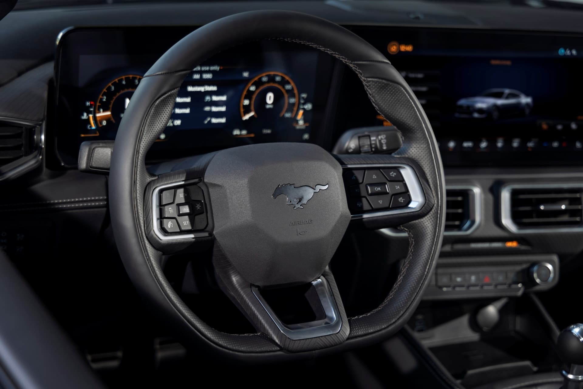 Vista nocturna del volante y panel de instrumentos del Mustang, destacando su iluminación y ergonomía.