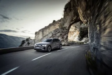 Vista dinámica del Audi Q8 e-tron en carretera de montaña.