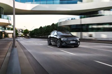Audi Q8 e-tron capturado en un entorno urbano, mostrando su perfil lateral.