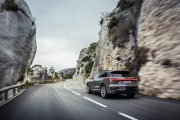 El Audi Q8 e-tron captado en pleno dinamismo por una carretera serpenteante.