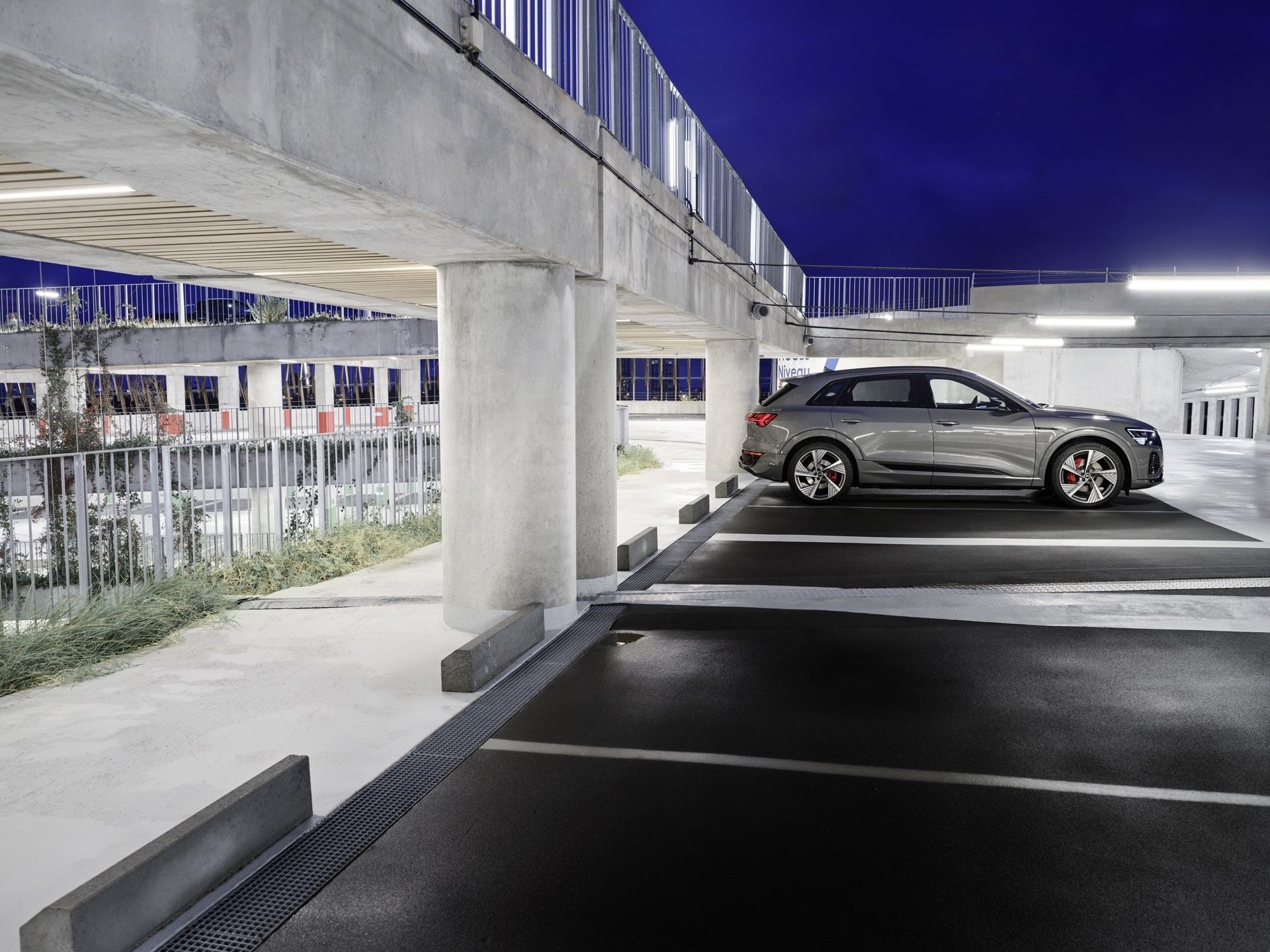 Vista lateral del Audi Q8 e-tron en un entorno nocturno, destacando su silueta dinámica.